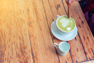 Hot green tea on a wooden background with morning light