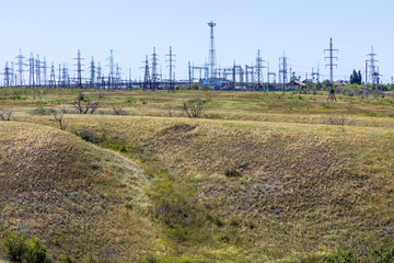 Obraz premium The russian steppe or prairie with ravines and blue sky near Volgograd city in the sunny summer day. The countryside landscape or view with electric or power substation, electric lines or mains 