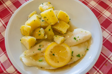 Plate of lemon butter sauce white fish in Italian restaurant