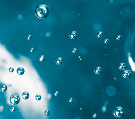 Bubbles of air on the smooth surface of blue water as an abstract background