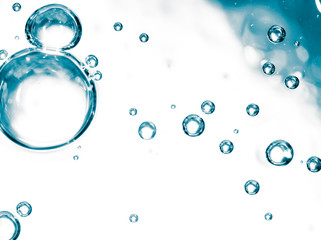 Bubbles of air on the smooth surface of blue water as an abstract background