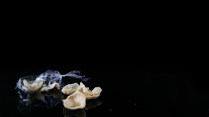 kerupuk isolated in black is Indonesian traditional crackers made from flour dough dried under sun before get fried
