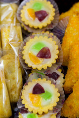 variety of traditional indonesian cake's inside plastic packaging on wood and white brick background