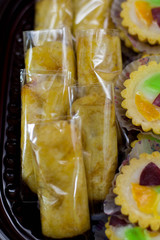 variety of traditional indonesian cake's inside plastic packaging on wood and white brick background