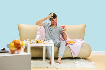 Young man suffering from allergy to citrus fruits. Having skin rash, itching, Sneezing in the...