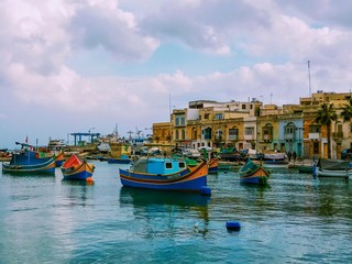 Fototapeta na wymiar Traditional fishing boats Luzzu moored at Marsaxlokk Harbor, Malta
