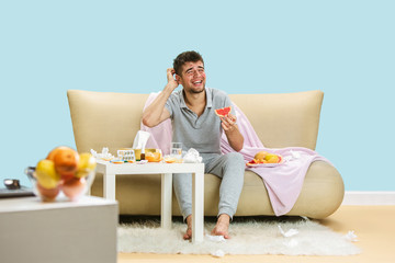 Young man suffering from allergy to citrus fruits. Having skin rash, itching, Sneezing in the...
