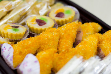 variety of traditional indonesian cake's inside plastic packaging on wood and white brick background