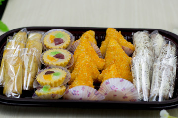 variety of traditional indonesian cake's inside plastic packaging on wood and white brick background