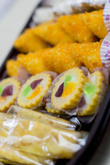 variety of traditional indonesian cake's inside plastic packaging on wood and white brick background