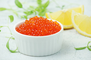 A small ceramic bowl with red caviar	