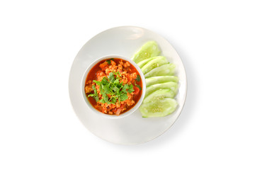 Top view. Thai Northern Style Pork and Tomato Relish in white bowl served with cucumber sliced isolated on white background, clipping path. Hot and spicy dipping.