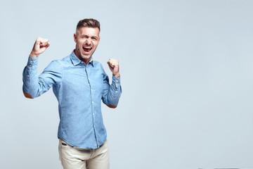Yeah, i did it Happy handsome bearded man is celebrating success and keeping hands clenched in...