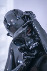 Man in the latex rubber black catsuit with gasmask