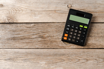 Calculator on wooden background with copyspace