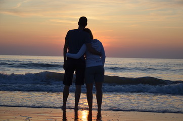 Couple amoureux devant un couché de soleil sur la plage