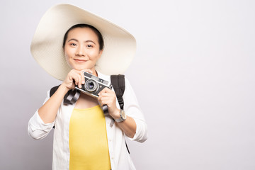 Happy woman holding camera over background and looking at camera