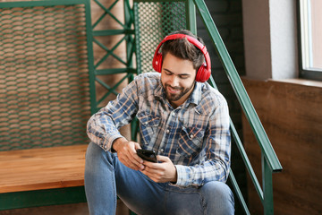 Young man listening to audiobook indoors