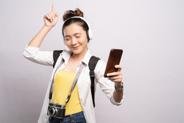 Tourist woman listening music from smartphone isolated over white background