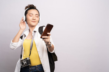 Tourist woman listening music from smartphone isolated over white background