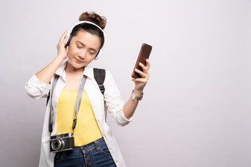 Tourist woman listening music from smartphone isolated over white background