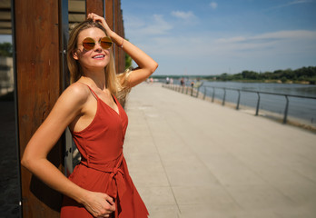 gorgeous beautiful woman in long red dress and  hat walking.  Portrait of happy girl in the morning...