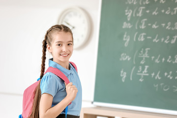 Cute little schoolgirl in classroom
