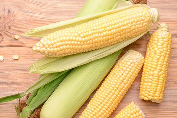 Fresh corn cobs on wooden background