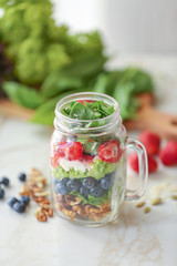 Mason jar with fresh tasty salad on table