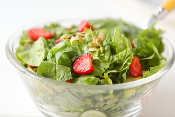 Bowl with fresh tasty salad on table, closeup