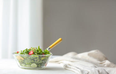 Bowl with fresh tasty salad on table