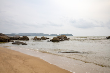 Fototapeta na wymiar Powerful wave from sea with Rock on the beach before raining storm in Phuket province of Thailand. 
