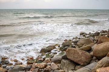 Fototapeta na wymiar Powerful wave from sea with Rock on the beach before raining storm in Phuket province of Thailand. 