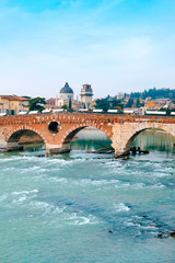 Naklejka premium Roman arch bridge over Adige River in Verona. Historical center of European city. Romantic sightseeng trip to Italy