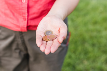 Women hand holding coins, the concept of business, natural green background in summer day