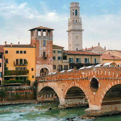Fototapeta na wymiar Roman arch bridge over Adige River in Verona. Historical center of European city. Romantic sightseeng trip to Italy