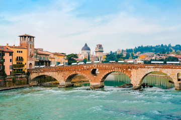 Fototapeta na wymiar Roman arch bridge over Adige River in Verona. Historical center of European city. Romantic sightseeng trip to Italy