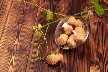 glass of wine with cork on wooden background.