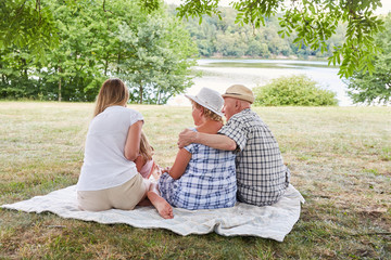 Erweiterte Familie auf einer Wiese am See