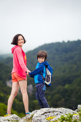 Fototapeta premium The boy with his mother on top of the mountain.