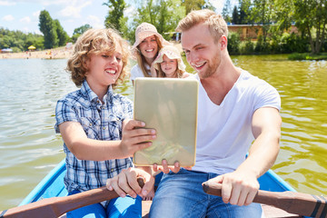Familie mit Tablet Computer auf einer Bootstour