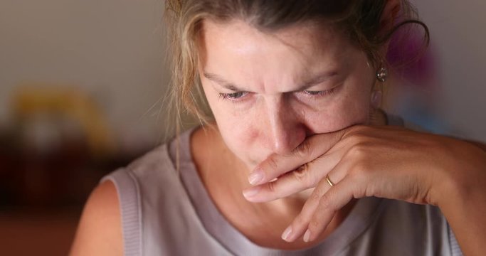 Woman face with worried look on her face holding smartphone device reading information on screen making her concerned