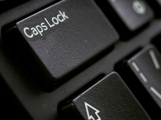 Dark keyboard Caps Lock button extreme close-up macro view