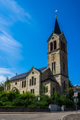 Fototapeta na wymiar Germany, Historical church building in kaisersbach near welzheim decorated by green trees under blue sky in summer