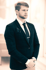 newcomer businessman in a business suit stands near the window,