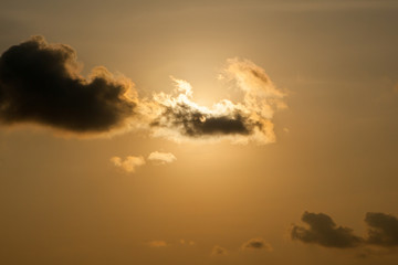 sun at sunset obscured by clouds at Thailand.