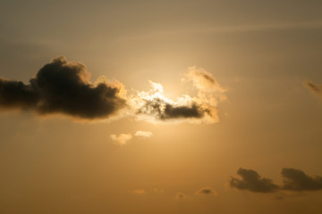 sun at sunset obscured by clouds at Thailand.