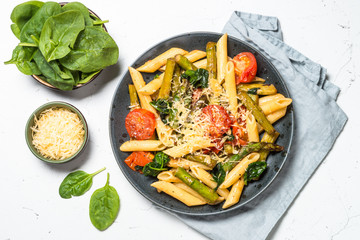 Vegan pasta penne with spinach, asparagus and tomato.
