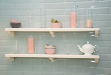 Shelves with decorative dishes. Delicate pink and white tones.