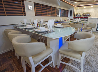 Interior of large salon dining area of luxury motor yacht